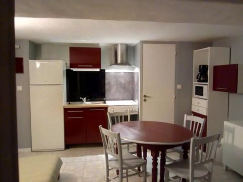 a kitchen with a table and chairs and a kitchen with a refrigerator at 7 Rue du Docteur Paul Jouve in Digne-les-Bains