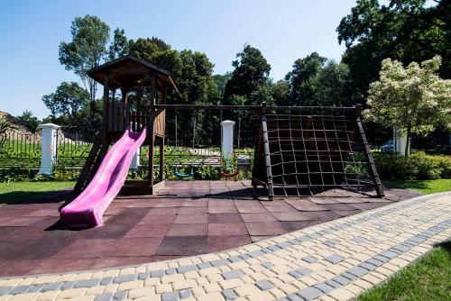 un parque infantil con un tobogán rosa en un parque en Pod Ksiecia Gorka, en Oleszyce