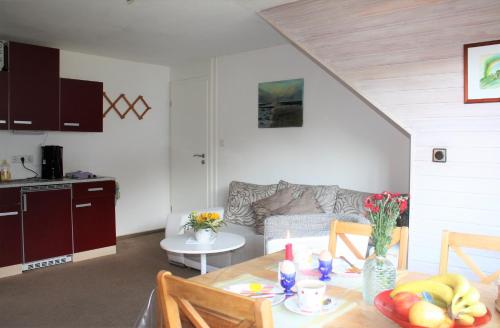 una cucina e un soggiorno con tavolo e divano di Ferienwohnung Hermann-Daur-Weg a Cuxhaven
