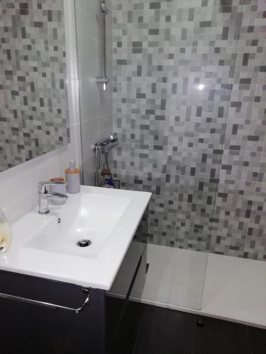 a bathroom with a white sink and a shower at Calle Maceiras, 1 - 1B in Combarro