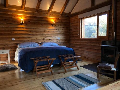 1 dormitorio con 1 cama en una cabaña de madera en Laguna Larga Lodge en Lago Futalaufquen
