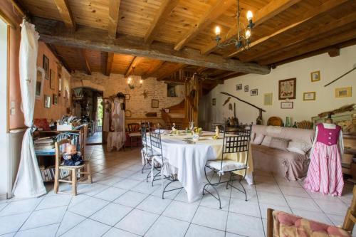 a dining room with a table and a couch at A L'Antan - La Ferme D'Octave in Saint-Hilaire-de-Villefranche