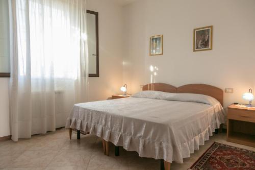 Un dormitorio con una cama grande y una ventana en Bed And Breakfast Eden Green, en Alghero