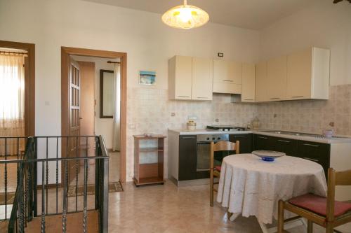 a kitchen with a table with a table cloth on it at Bed And Breakfast Eden Green in Alghero