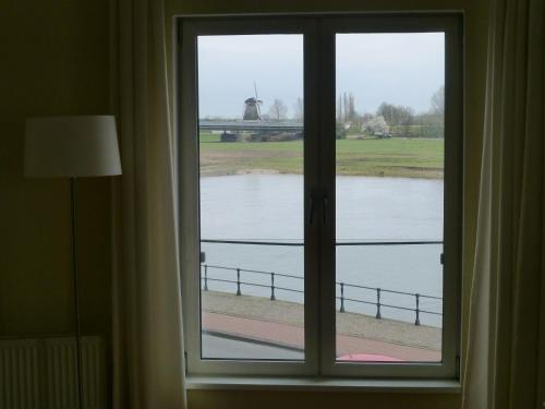 a window with a view of a body of water at Hotel de Vischpoorte, centrum Deventer en aan de IJssel in Deventer