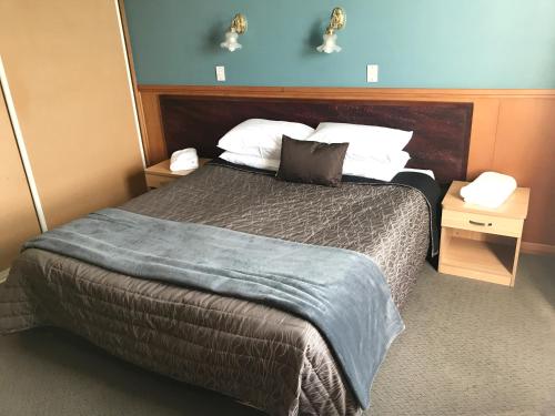 a bedroom with a large bed with two night stands at The Pier Hotel in Kaikoura