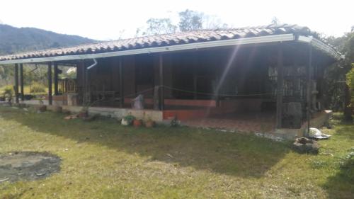 a house with a large roof on a yard at Hospedaje Rural Misia Emilia in Medellín