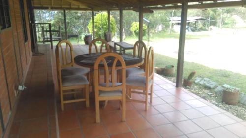 a porch with a table and chairs on it at Hospedaje Rural Misia Emilia in Medellín