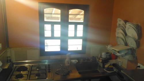 a kitchen with a stove and a window at Hospedaje Rural Misia Emilia in Medellín