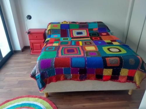 - une couette colorée sur un lit dans l'établissement Apartamento cómodo y tranquilo con WiFi en Boedo, à Buenos Aires