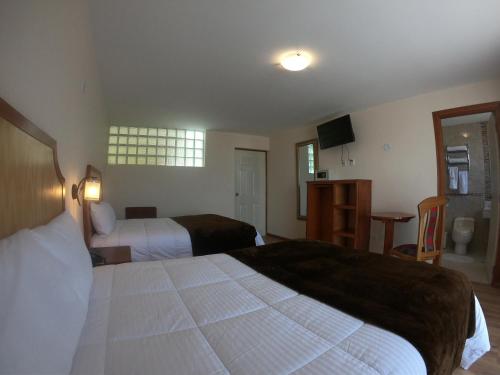 a hotel room with two beds and a television at Sol Plaza Hotel in Puno