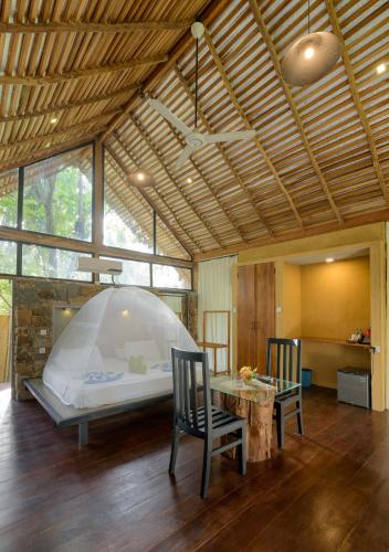 a room with a bed and two chairs and a table at Kottawatta Village in Udawalawe