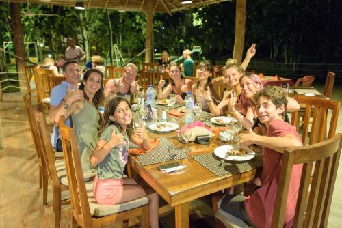 a group of people sitting around a wooden table at Kottawatta Village in Udawalawe
