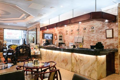 un restaurant avec un comptoir avec des chaises et une table dans l'établissement Kiwi Hotel MRT Wenxin Branch (Feng Chia Branch 1), à Taichung
