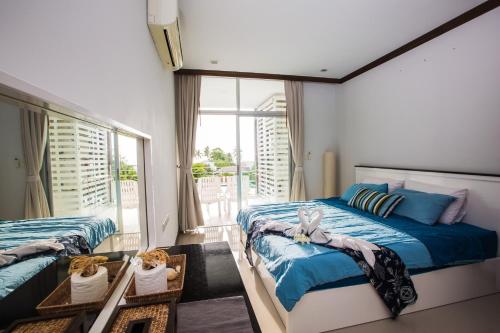 sypialnia z 2 łóżkami i dużym oknem w obiekcie At Seacondo-2 Bedrooms-B35 w mieście Klong Muang Beach