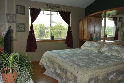 A bed or beds in a room at River Rose B&B