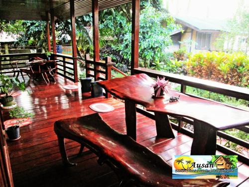 a wooden deck with a wooden table and benches at Ausan Beach Front Cottages in San Vicente