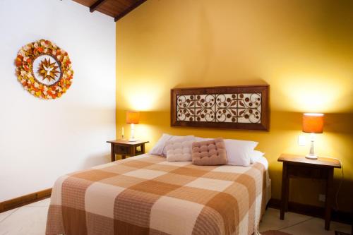 a bedroom with a bed with two lamps on two tables at Recanto das Andorinhas Studios in Paraty