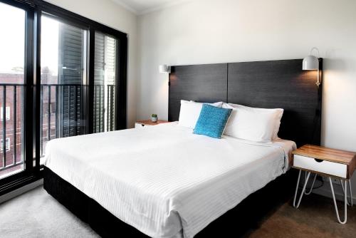 a bedroom with a large bed and a large window at Veriu Randwick in Sydney