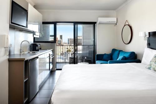 a hotel room with a large bed and a kitchen at Veriu Randwick in Sydney