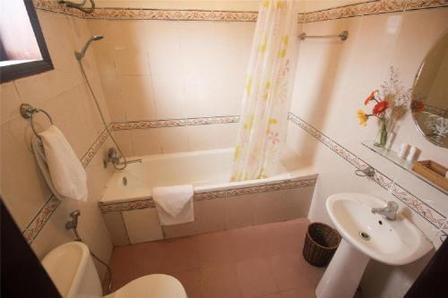 a bathroom with a tub and a sink and a toilet at DK's Backpacker Hotel in Hoi An