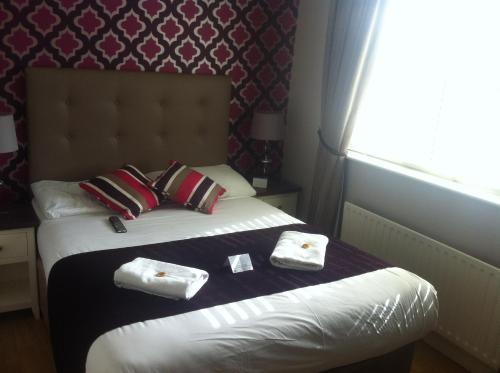 a hotel room with a bed with towels on it at Abbey Lodge B&B in Galway
