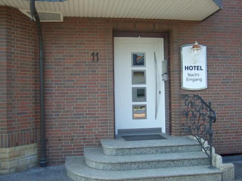 a brick building with a door with a sign on it at Hotel Rose in Georgsmarienhütte