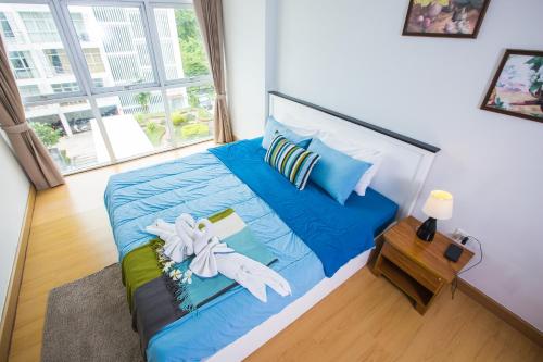 sypialnia z dużym łóżkiem z niebieską pościelą i poduszkami w obiekcie At Seacondo-1 Bedroom-A20 w mieście Klong Muang Beach