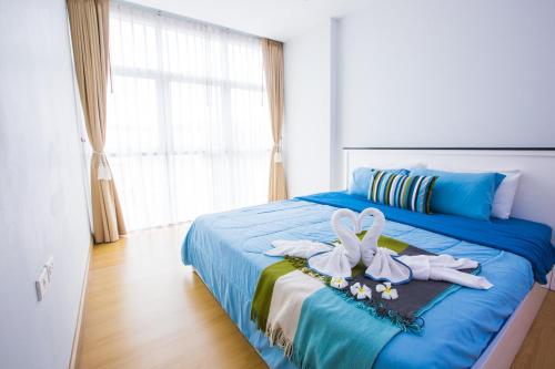 At Seacondo-1 Bedroom-A25 في كلونغ موانغ بيتش: غرفة نوم بسرير ازرق عليها لعبة أرنب