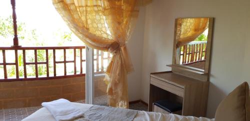 a bedroom with a bed and a mirror and a window at Arora Inn in Maafushi