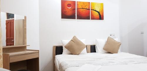 a bedroom with a bed and a painting on the wall at Arora Inn in Maafushi