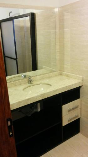 a bathroom with a sink and a mirror at Hotel Puesta del Sol by Nobile in Encarnación