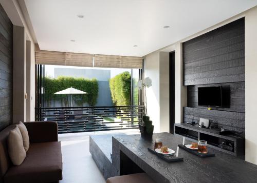 a living room with a couch and a table at eqUILIBRIA Seminyak in Seminyak