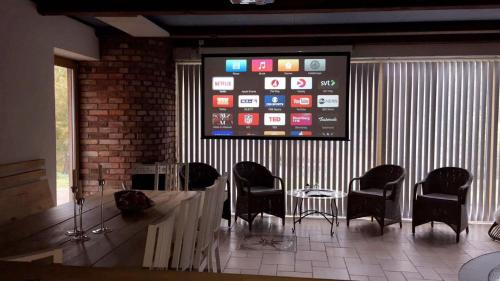 a waiting room with chairs and a large screen at Sjöborg Säng & Bassäng in Munka-Ljungby