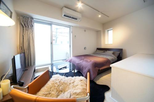a small bedroom with a bed and a window at Sorapia Tokyo in Tokyo