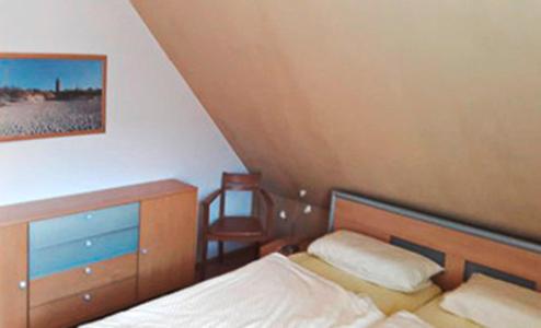 Schlafzimmer mit einem Bett, einem Schreibtisch und einem Stuhl in der Unterkunft Ferienwohnung Buchenpark in Prerow