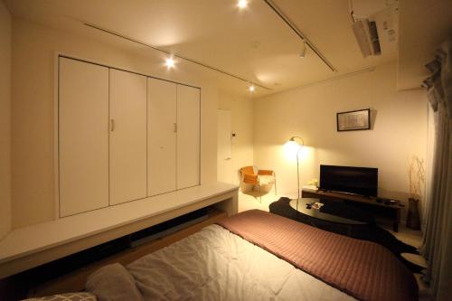a bedroom with a bed and a large cabinet at Sorapia Tokyo in Tokyo