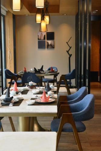 a dining room with tables and blue chairs at LN Hotel Five in Guangzhou