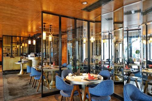a restaurant with blue chairs and tables and windows at LN Hotel Five in Guangzhou