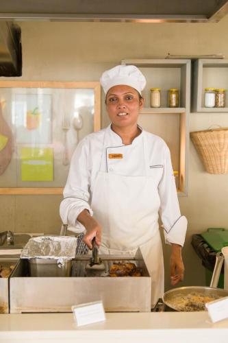 - un chef debout dans une cuisine préparant des plats dans l'établissement Tropical Attitude (Adults Only), à Trou dʼ Eau Douce
