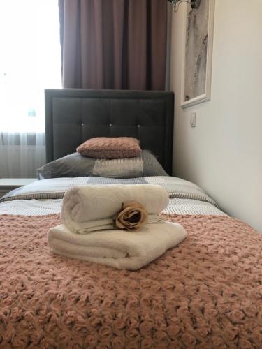 a bed with a towel with a scarf on it at Family & Business Sauna Apartments No1 Leśny nad Zalewem Cedzyna Unikat - 3 Bedroom with Private Sauna, Bath with Hydromassage, Terrace, Garage, Catering Options in Kielce