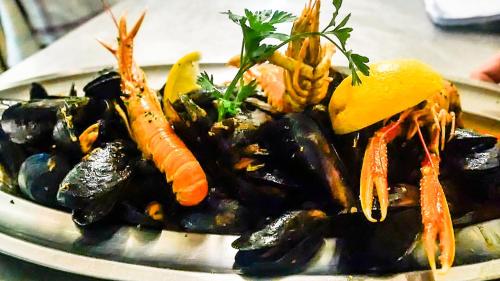 a plate of mussels with carrots and other vegetables at Villa Padova in Rab