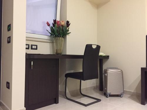 a desk with a chair and a vase of flowers at Grand Hotel Royal in Pompei