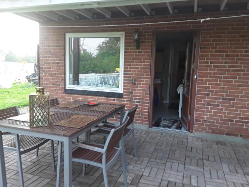 un patio con tavolo, sedie e finestra di Kjellerup bed&Breakfast a Kjellerup