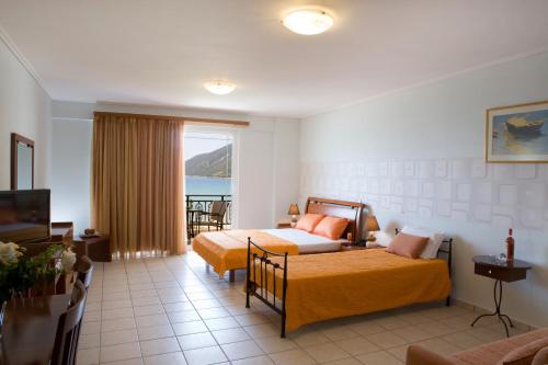a hotel room with two beds and a balcony at Hotel Grand Nefeli in Vasiliki