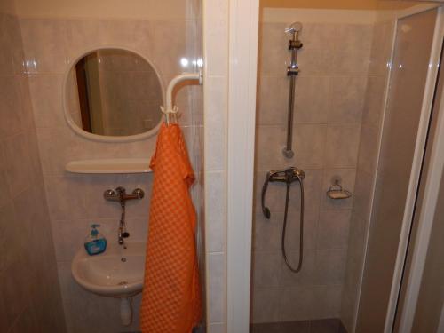 an orange shower curtain is hanging in a bathroom at PENZION MANĚTÍN u Sv. Barbory in Manětín