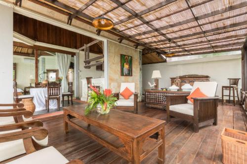 a living room with a table and chairs at Casa Jimbaran Villa in Jimbaran