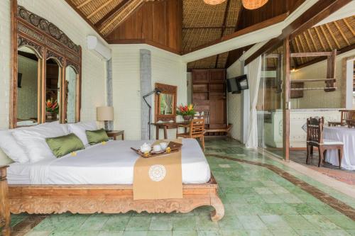 a bedroom with a bed with a table in it at Casa Jimbaran Villa in Jimbaran
