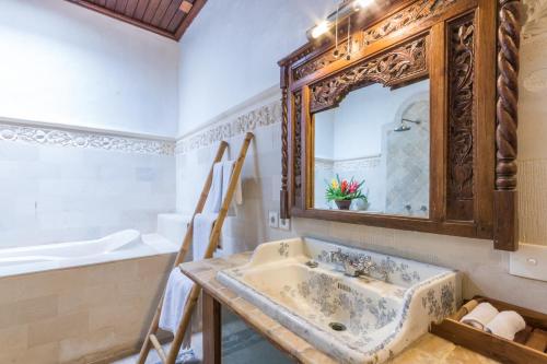 a bathroom with a sink and a mirror at Casa Jimbaran Villa in Jimbaran