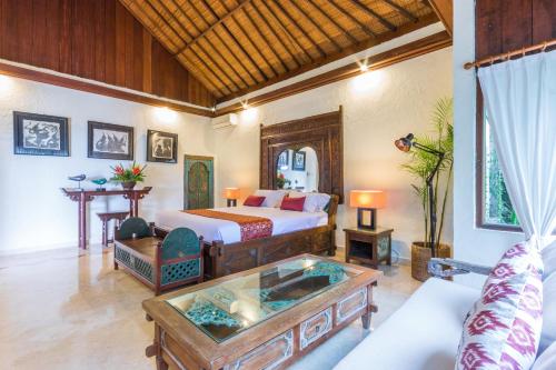 a hotel room with a bed and a table at Casa Jimbaran Villa in Jimbaran